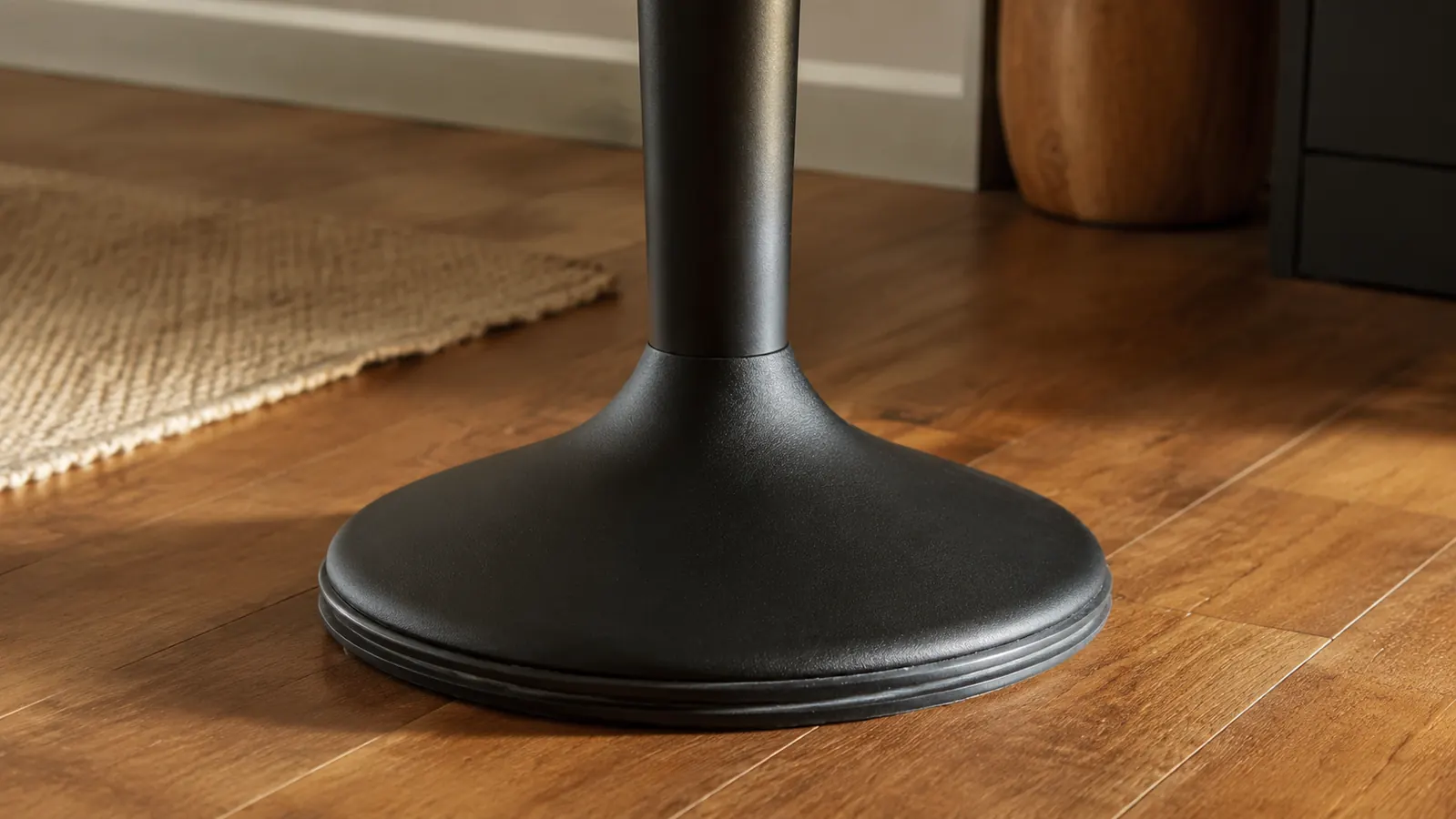 Close-up of the steel frame and non-slip base of a wobble stool on a hardwood office floor